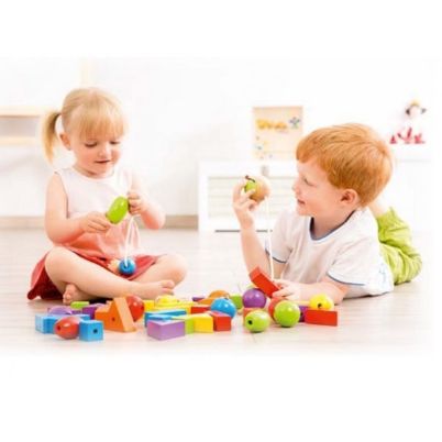 Παιδικό χέρι που τοποθετεί ένα ξύλινο χρωματιστό σχήμα στην κάμπια του σετ 25550 της Beleduc.