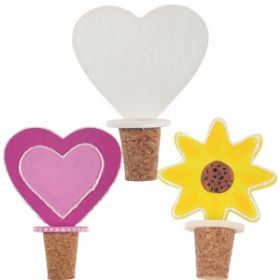 Το σετ 2 τεμαχίων Beleduc 50132 με τους φελλούς και τα ξύλινα διακοσμητικά σε σχήμα καρδιάς και λουλουδιού και διακοσμημένοι φελλοί Beleduc 50132 με έντονα χρώματα και σχέδια, έτοιμοι για δώρο.