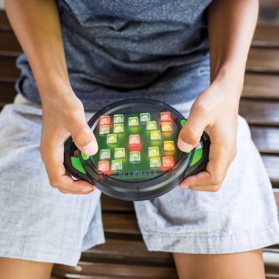 Ένας παίκτης που πατάει τα κουμπιά του Brainbolt 8435 ακολουθώντας τη φωτεινή αλληλουχία.