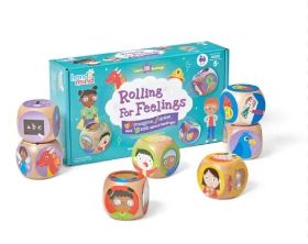 Τα 7 ξύλινα ζάρια του Rolling for Feelings 95387 μαζί με τις μεγάλες αφίσες συναισθημάτων παρατεταγμένα.