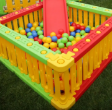 Τα μπαλάκια King Kids BL110004 King Ball 90mm μέσα σε πλαστική πισίνα, σε εξωτερικό χώρο, έτοιμα για παιχνίδι.
