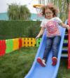 Παιδί που γλιστράει πάνω στην King Kids ST9061 Πλαστική Τσουλήθρα Αρκουδάκι, σε εξωτερικό χώρο.